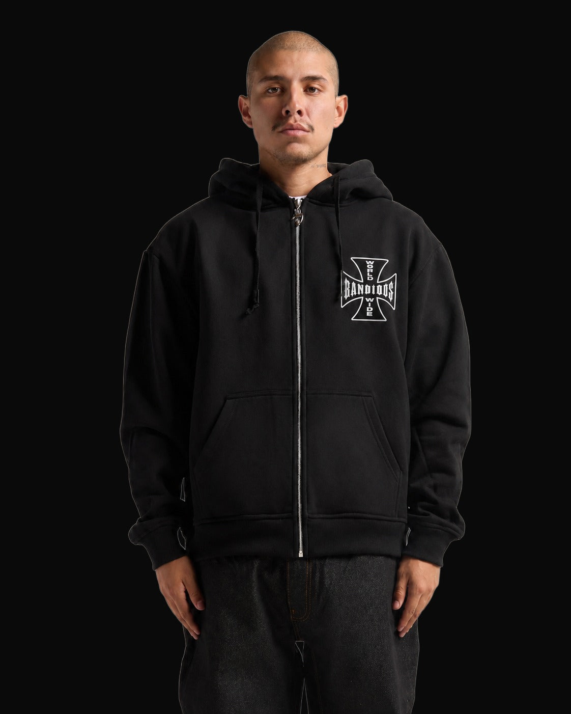 BANDIDOS STAPLE HOODIE front on model – black zip hoodie with white cross logo on the chest